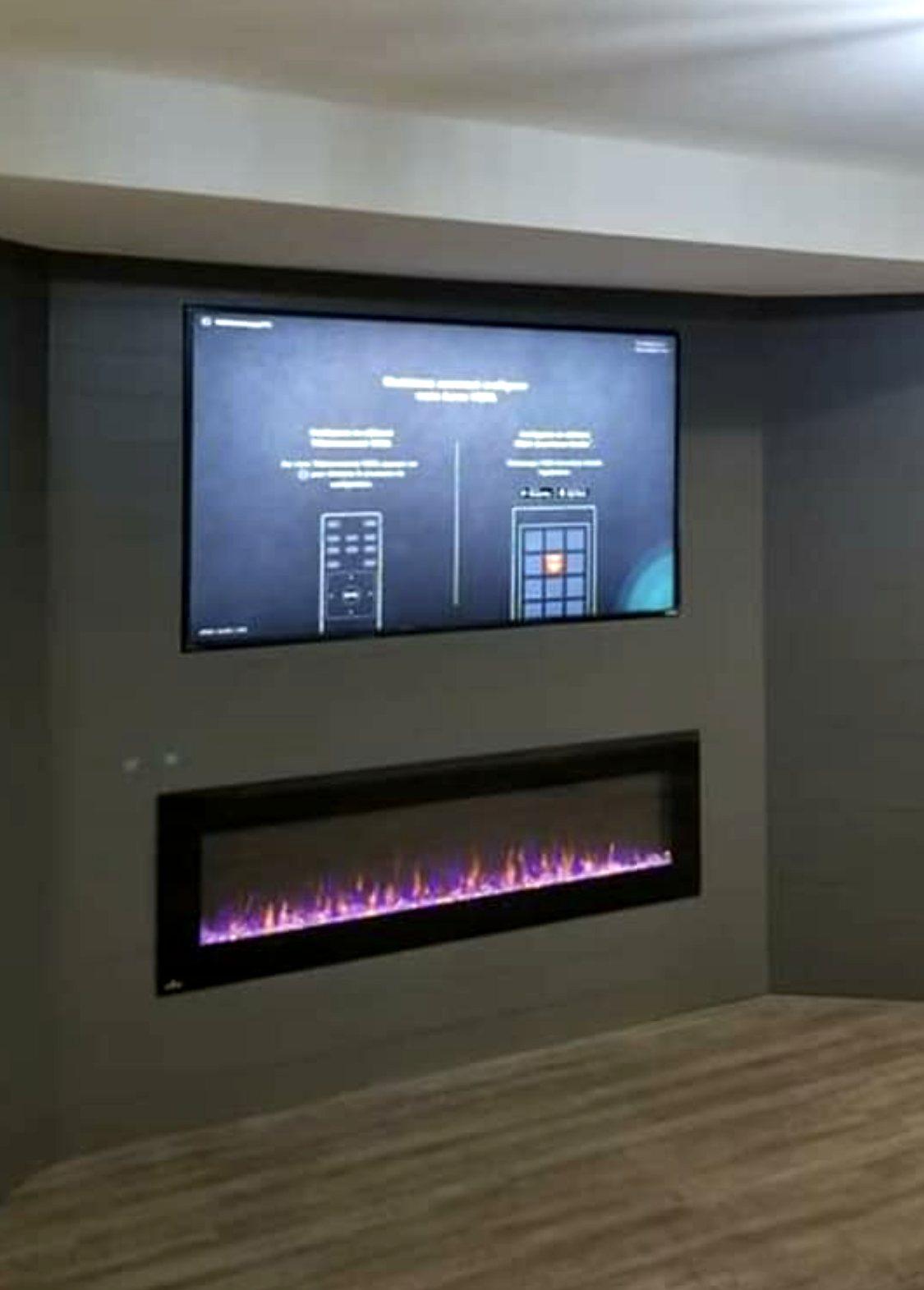 Finished basement media wall with a charcoal accent wall, wall-mounted TV and a built-in linear electric fireplace