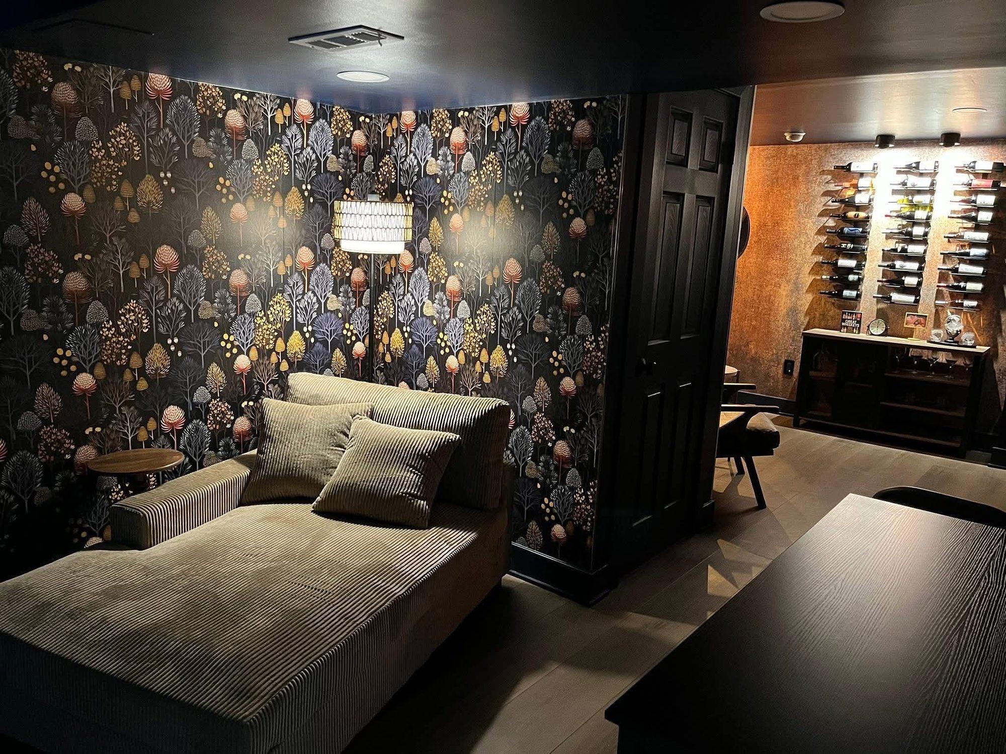 Basement lounge with dramatic botanical wallpaper, chaise seating and dark trim