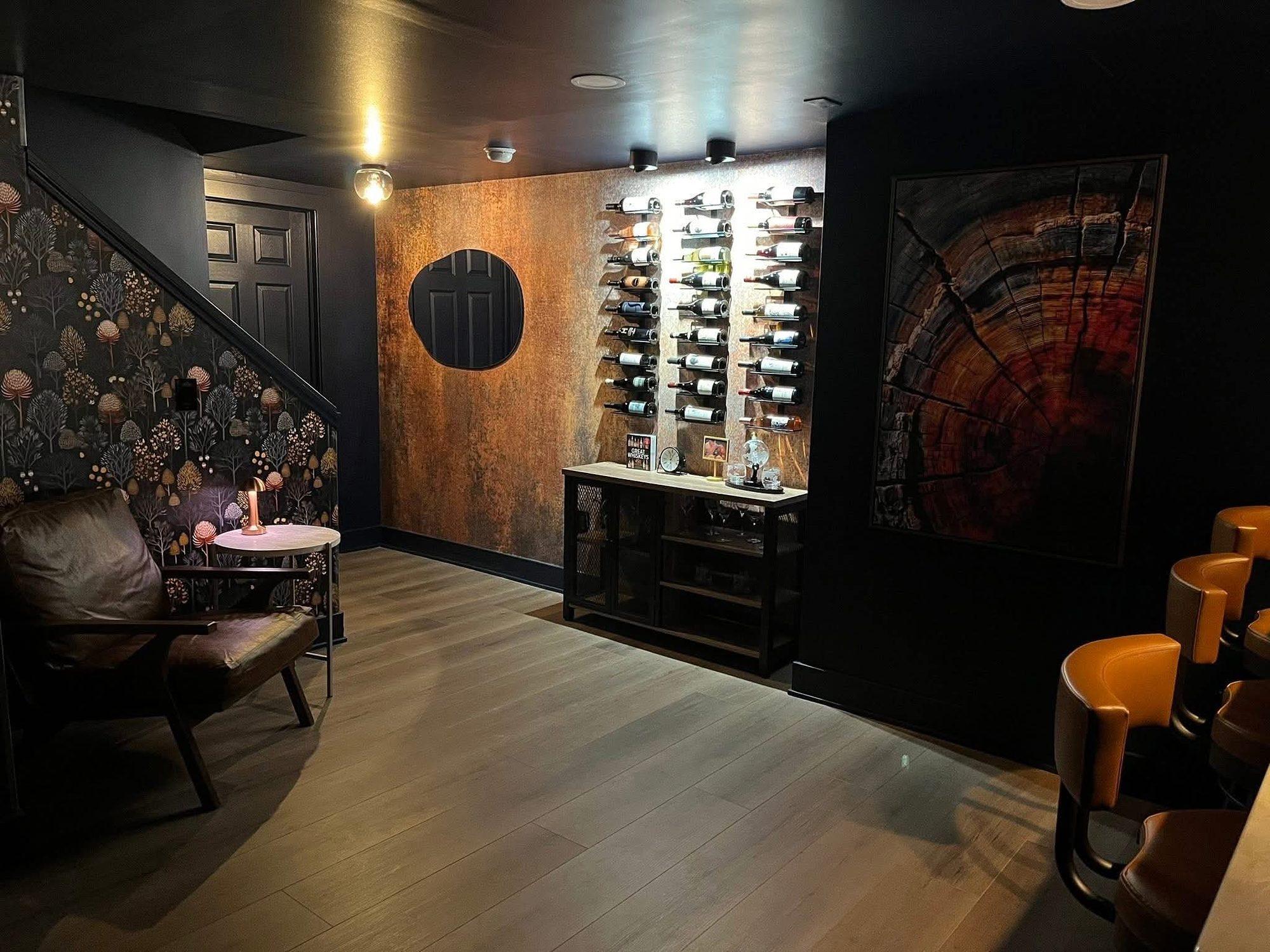 Basement lounge with a lighted wine wall, round accent, copper-finish feature wall and botanical wallpaper