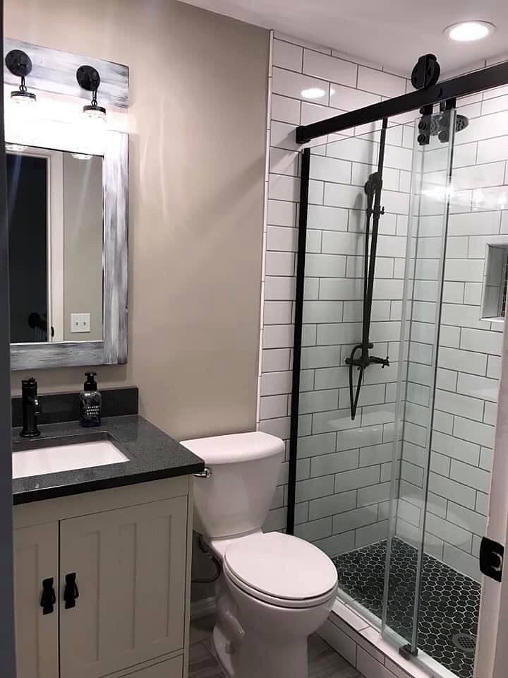 Bathroom remodel with subway tile shower, matte black fixtures, barn-style glass door and hex tile floor