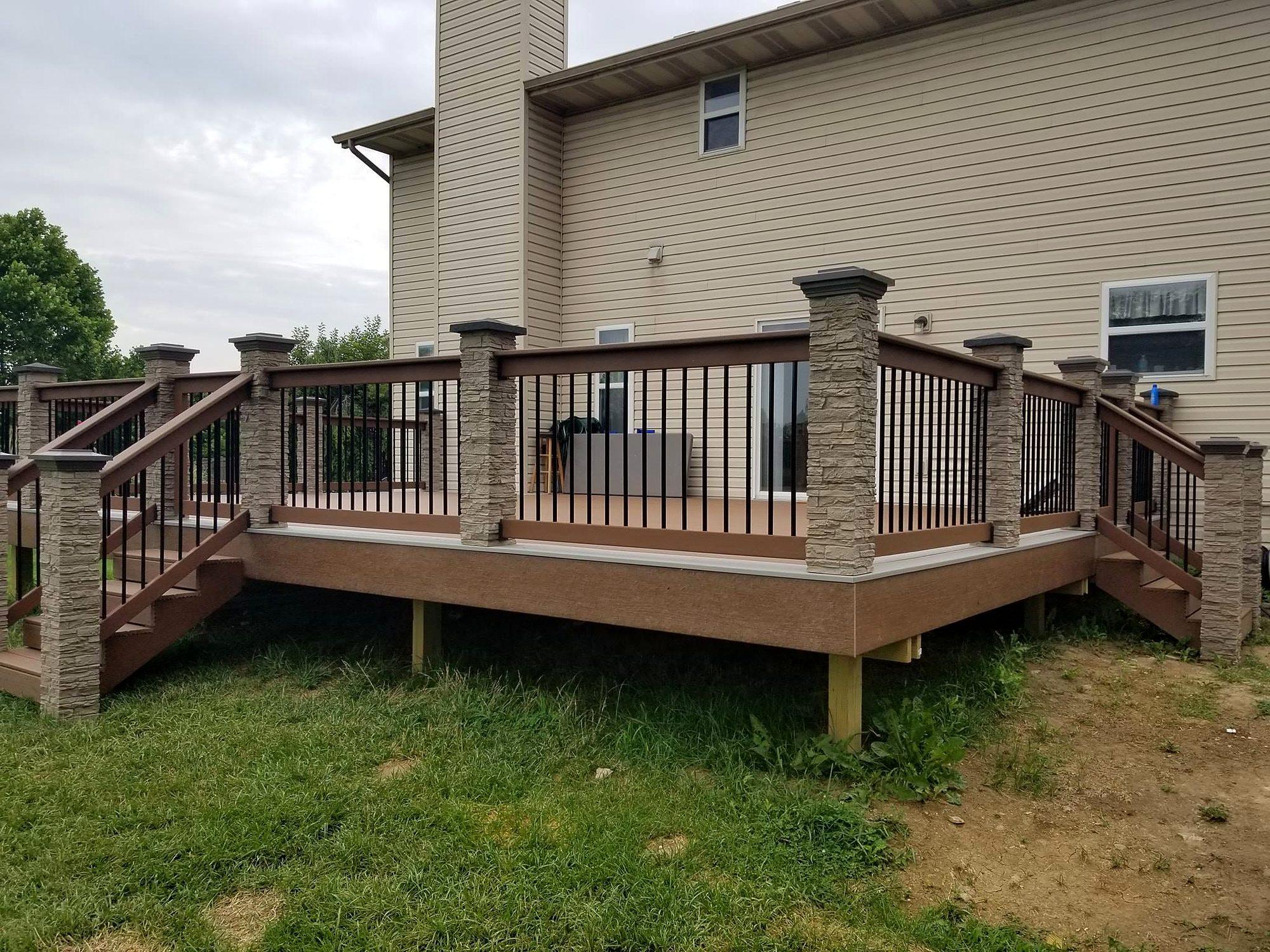 Two-tone composite deck with stacked-stone columns, black balusters and double stairways