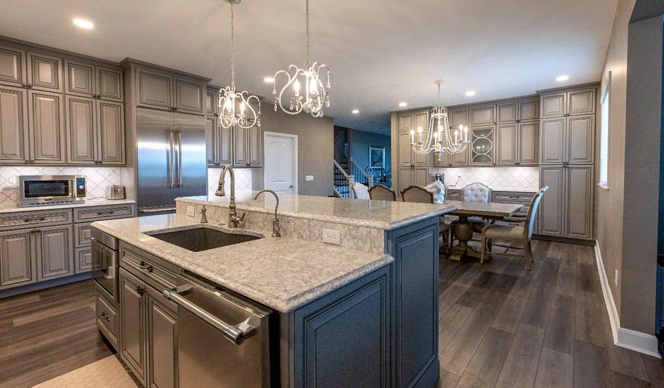Kitchen remodel opening to the dining room with a large island, stainless appliances and gray cabinetry