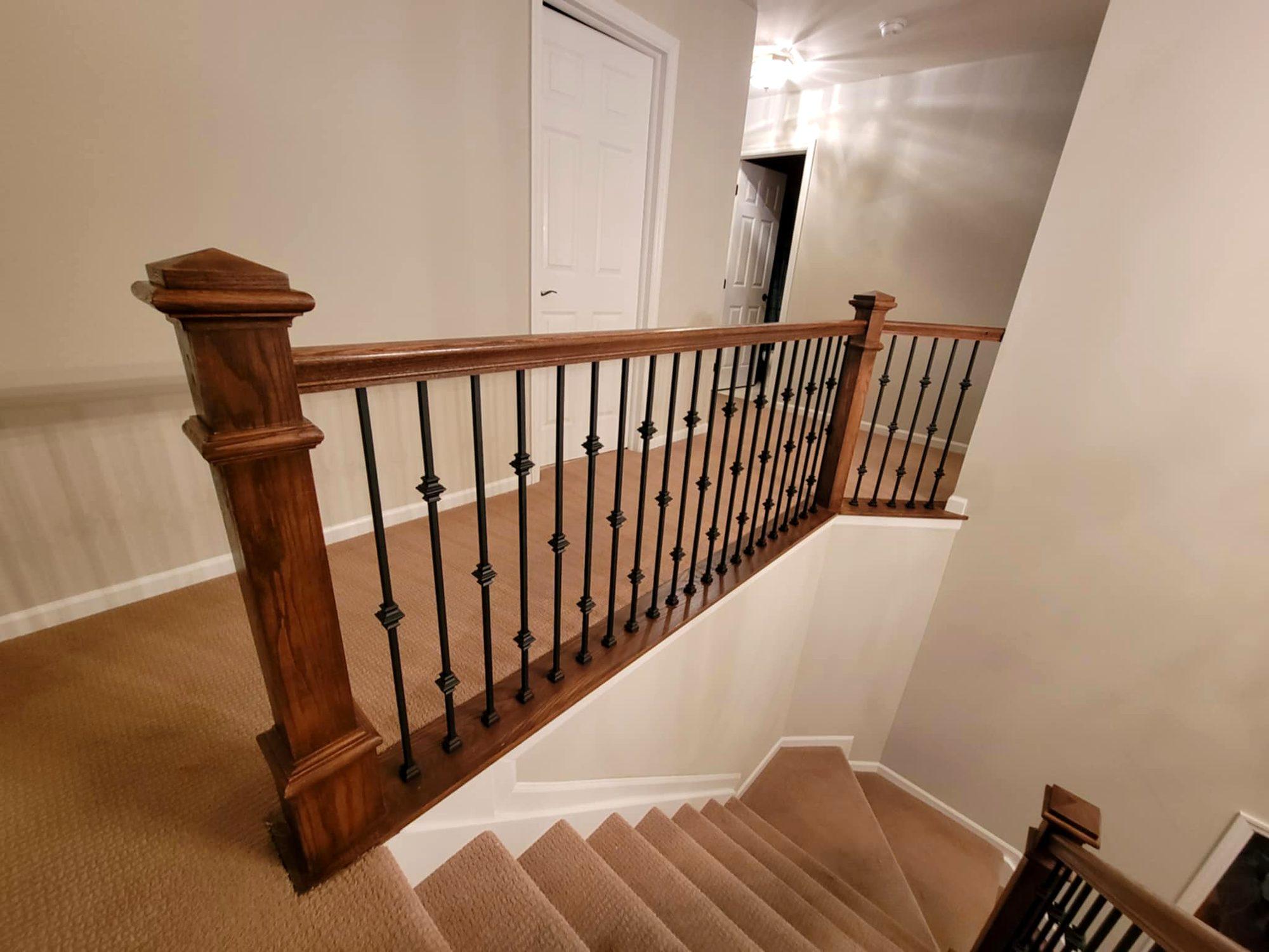 Custom stained newel post and wrought-iron baluster railing