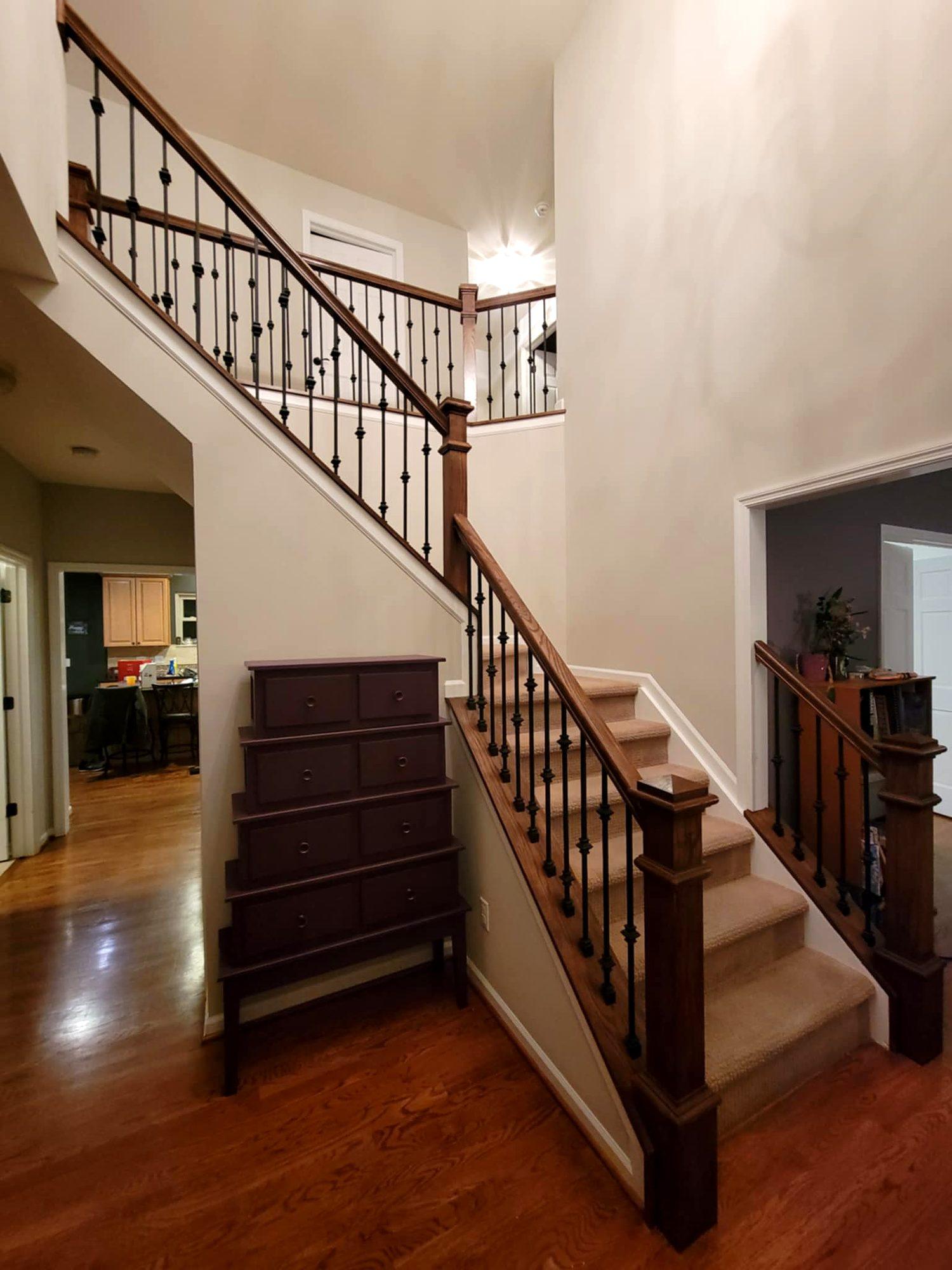 Staircase renovation with stained oak handrail, newel posts and wrought-iron balusters