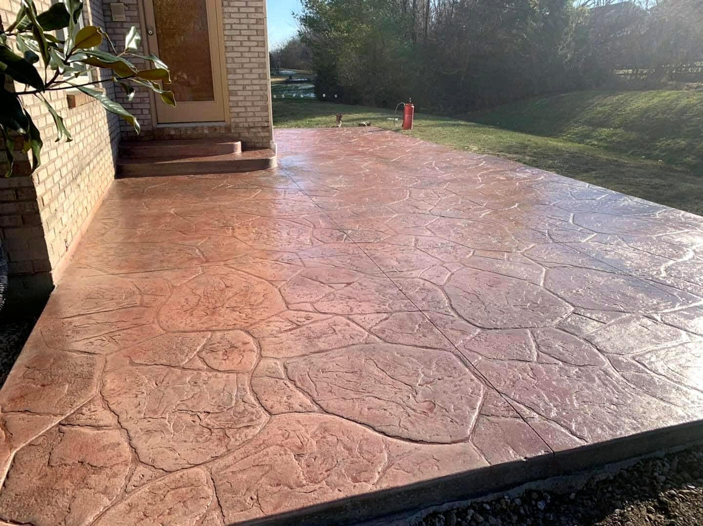 Red-toned stamped concrete patio with a natural flagstone pattern